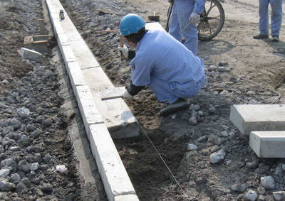 牙石安裝完畢，工人正在安裝平石